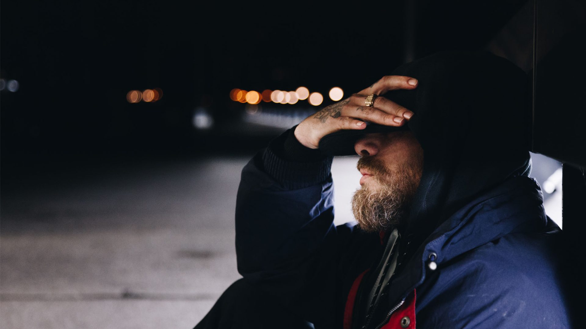 Rough sleeper with hand on his head