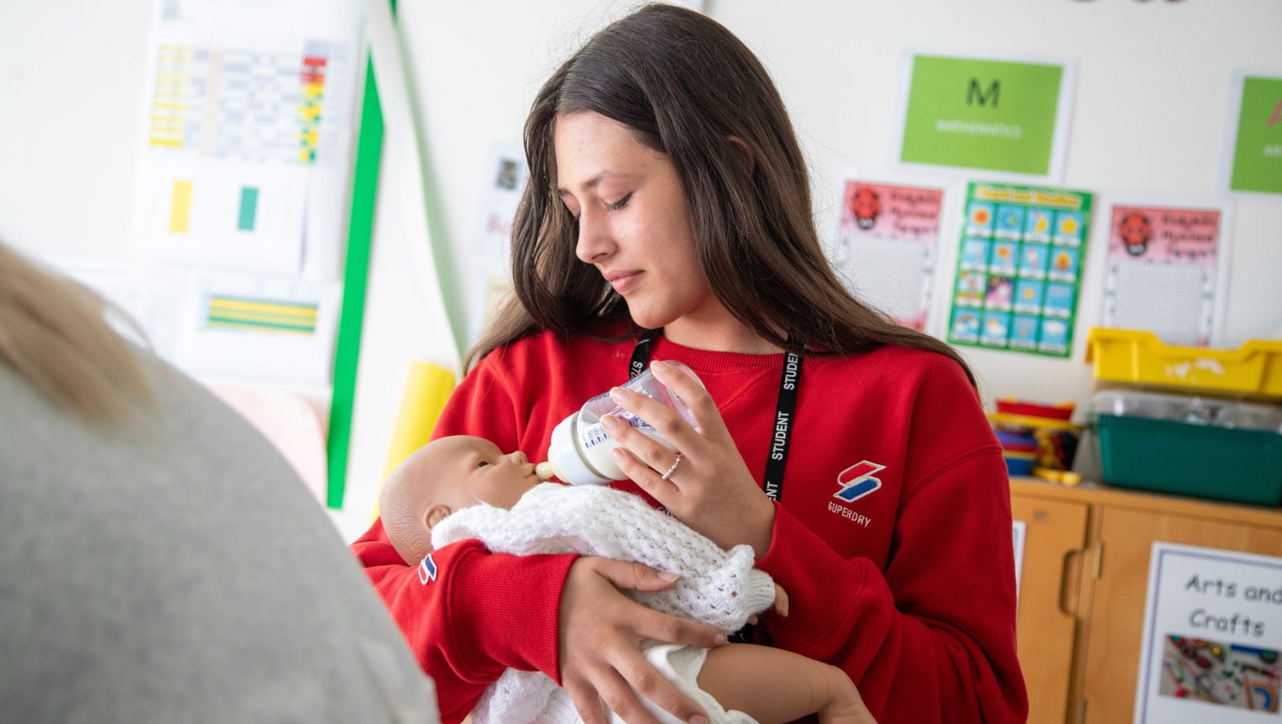 Childcare student feeding a baby